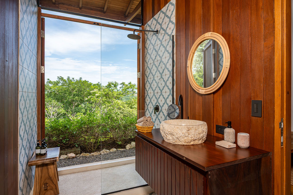 Bedroom one vanity with the shower door open to the canopy