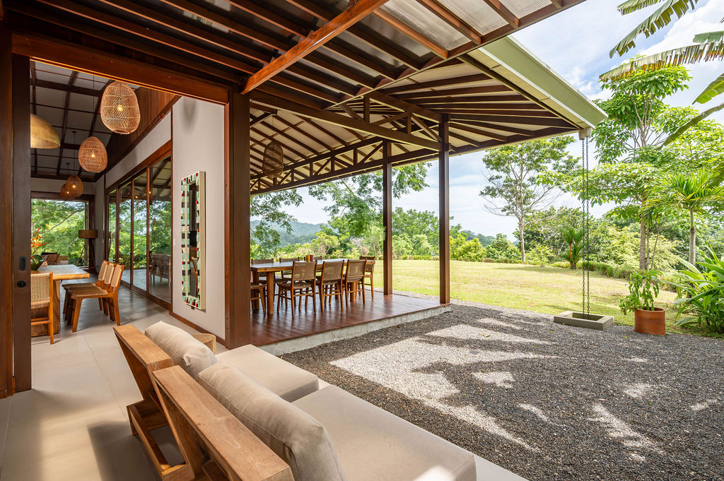 Covered terrace lounge looking through the open-air dining pavilion to the lawn