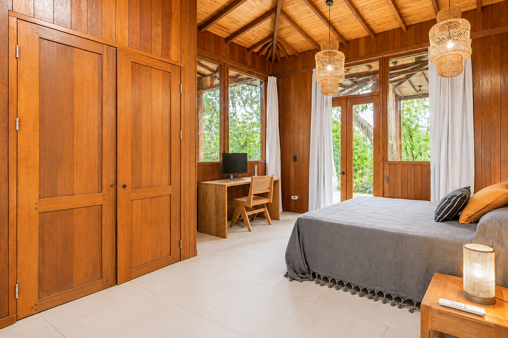 Jungle residence bedroom with large windows onto dense forest
