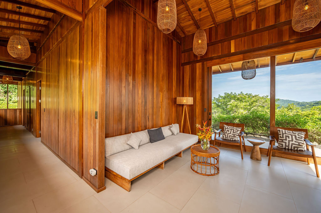 Guest lounge wide view with woven pendants and terrace chairs beyond