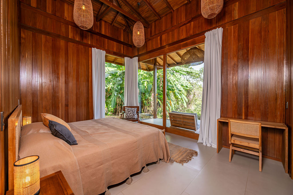 Guest bedroom two with king bed, desk and banana-palm window wall