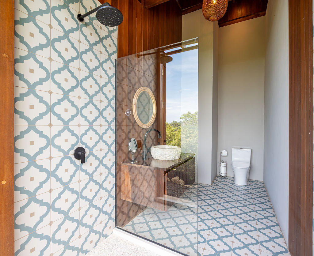 Bedroom one bathroom with patterned tile shower and glass partition