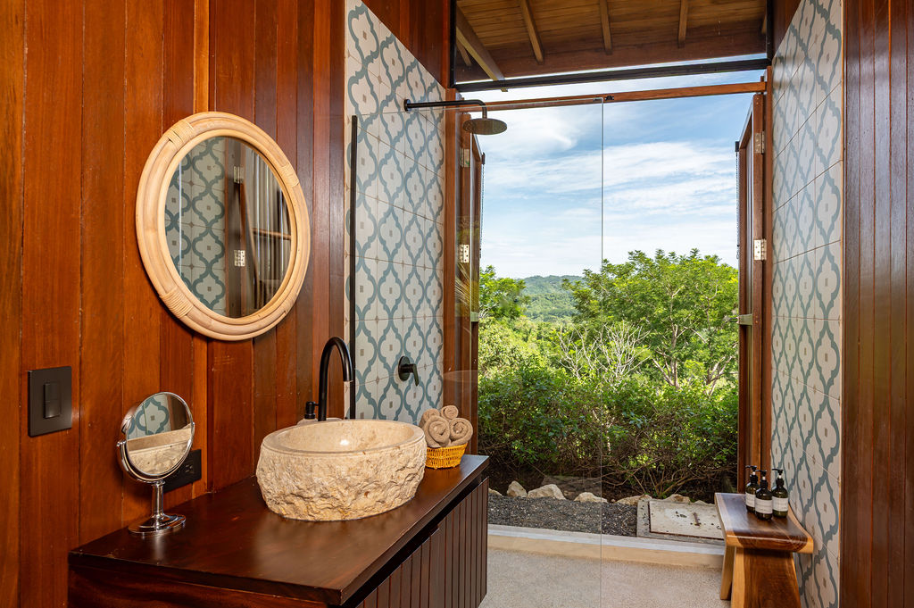 Bedroom two vanity with the door open to the outdoor rain shower