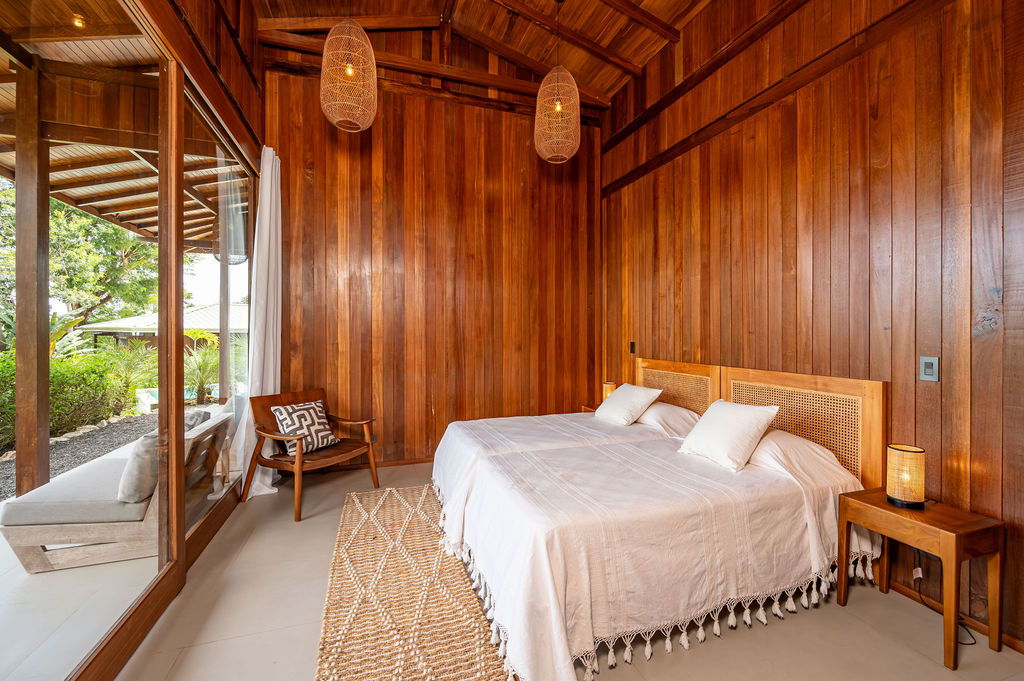 Guest bedroom one with caned headboard, jute rug and window bench