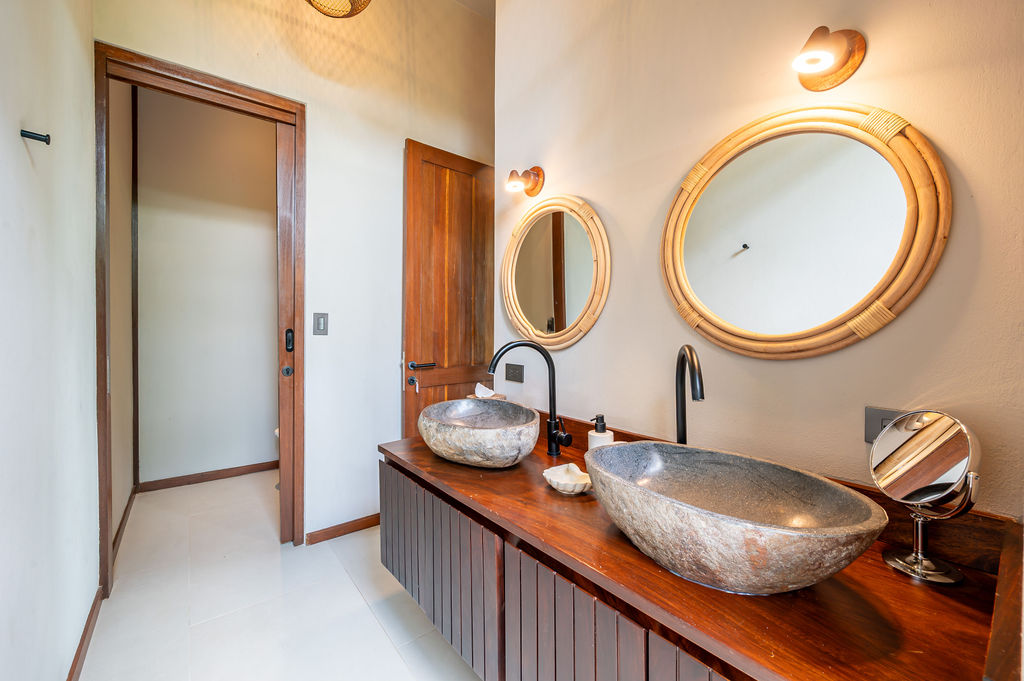 Close view of the double stone basins and rattan mirrors