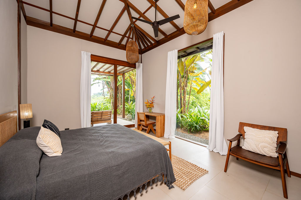 Bedroom two with writing desk and twin glass doors to the garden