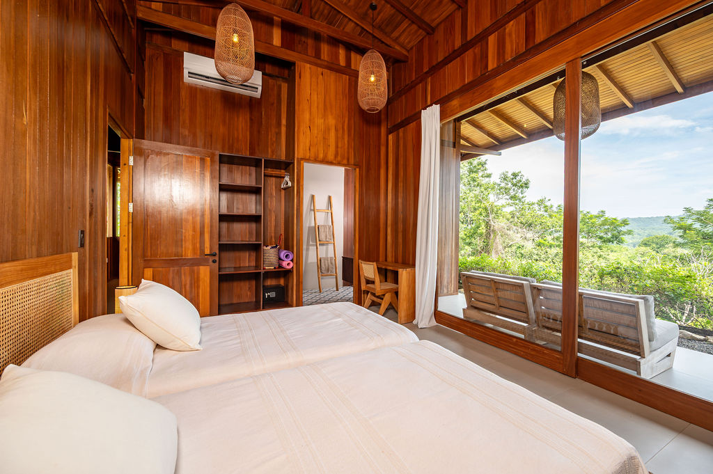 Guest bedroom one wide view with open slider to the terrace bench